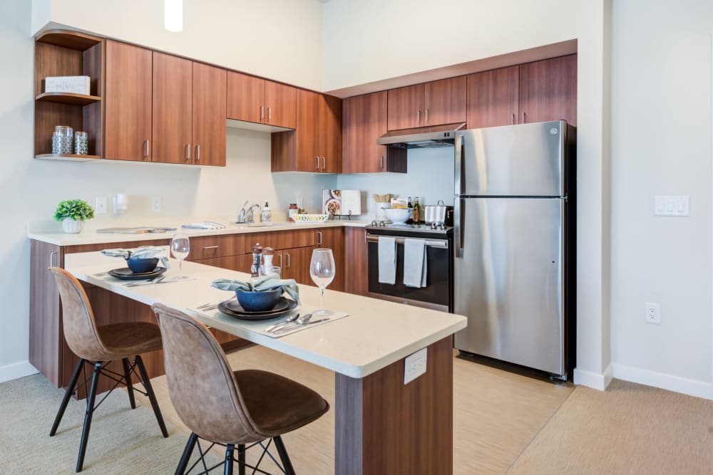 A modern kitchen with stainless steel appliances and a dining area.