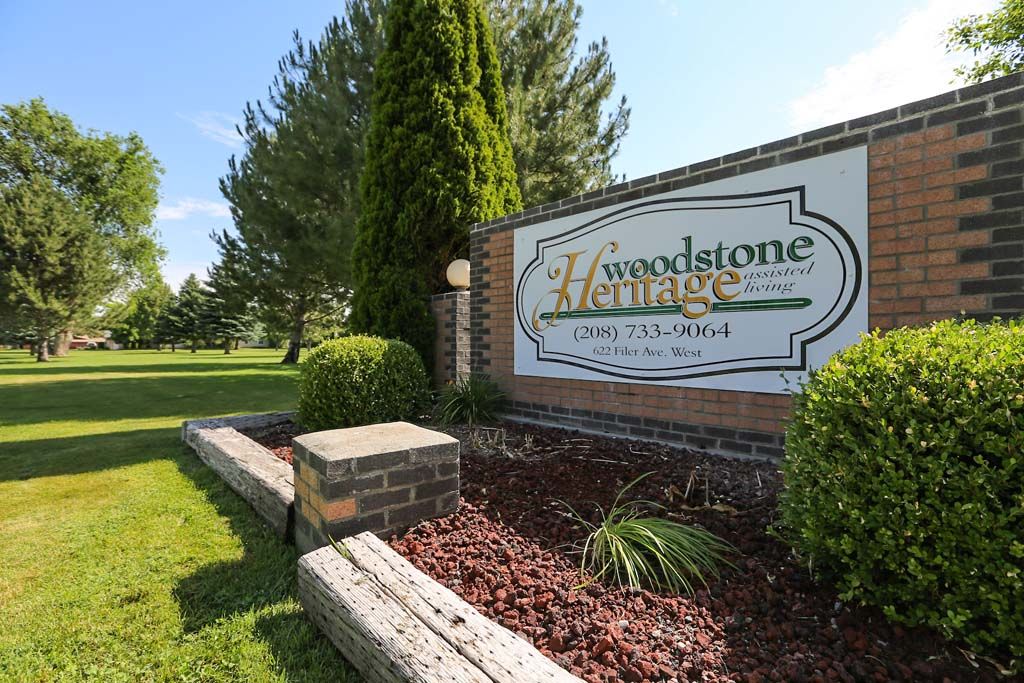 Entrance sign for Woodstone Hirmitage Community with well-maintained landscaping.