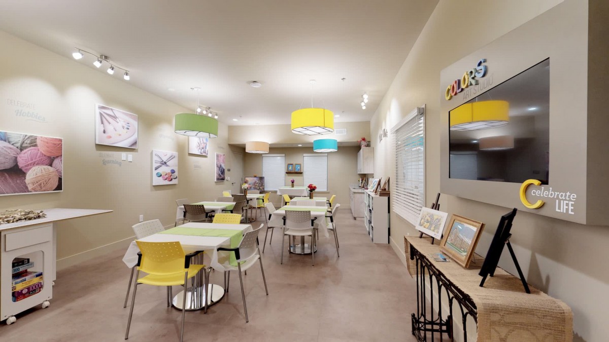 Modern cafe interior with colorful chairs and artwork on the walls.
