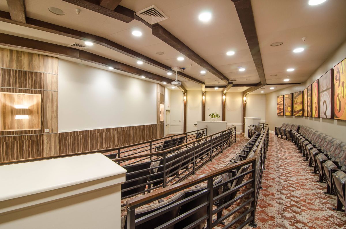 An indoor theater room with rows of seating and a large screen.