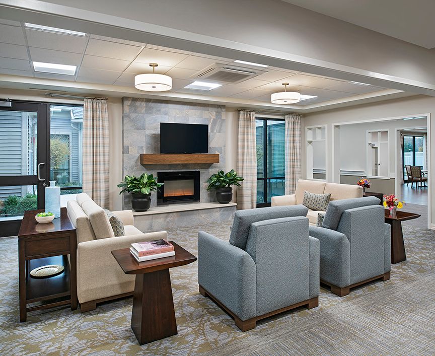 A modern living room with elegant furniture, featuring a cozy fireplace and a mounted television.