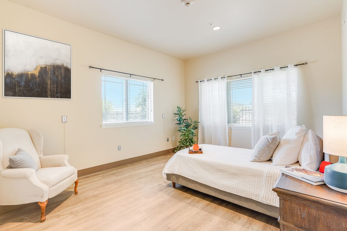 A bright, minimalist bedroom with wooden flooring and contemporary decor.