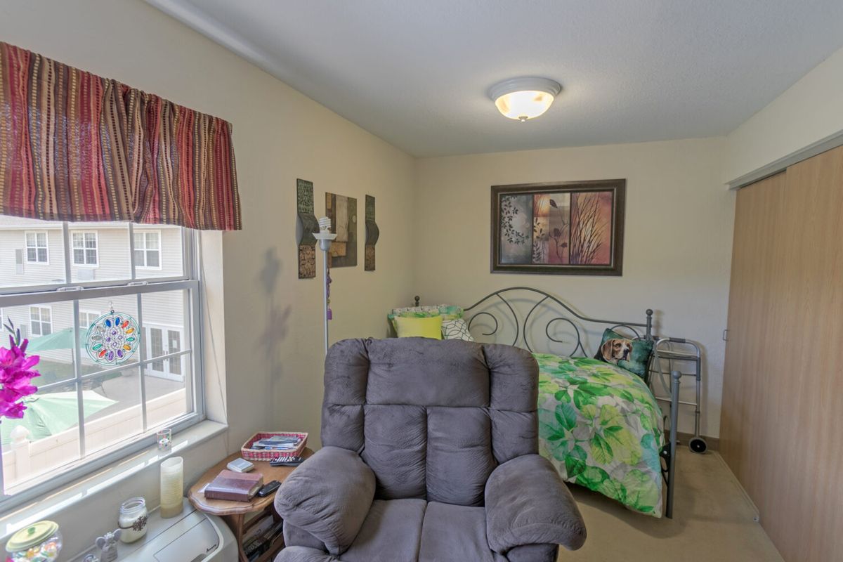 A cozy living room with an armchair, bed, and decorative elements.