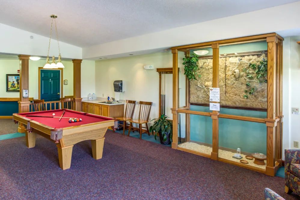 A cozy game room featuring a pool table and comfortable seating.