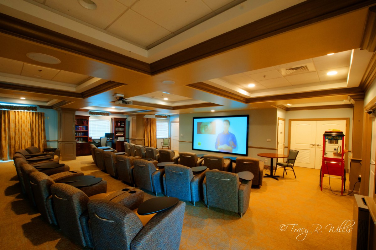 A spacious luxury home theater with comfortable seating and a large projector screen.