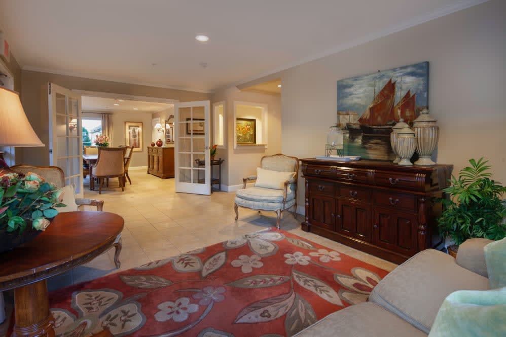 A well-decorated living room featuring comfortable seating, elegant furniture, and decorative artwork.