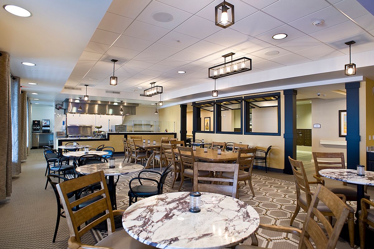A modern restaurant dining area with stylish lighting and wooden furniture.