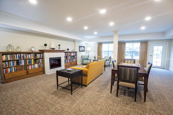 Spacious living room with a cozy fireplace, bookshelves, and a dining area.
