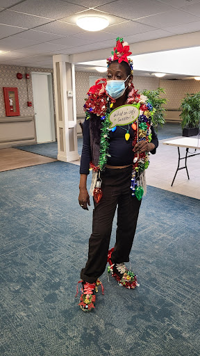 A person dressed in vibrant holiday decorations, spreading festive cheer while wearing a mask.