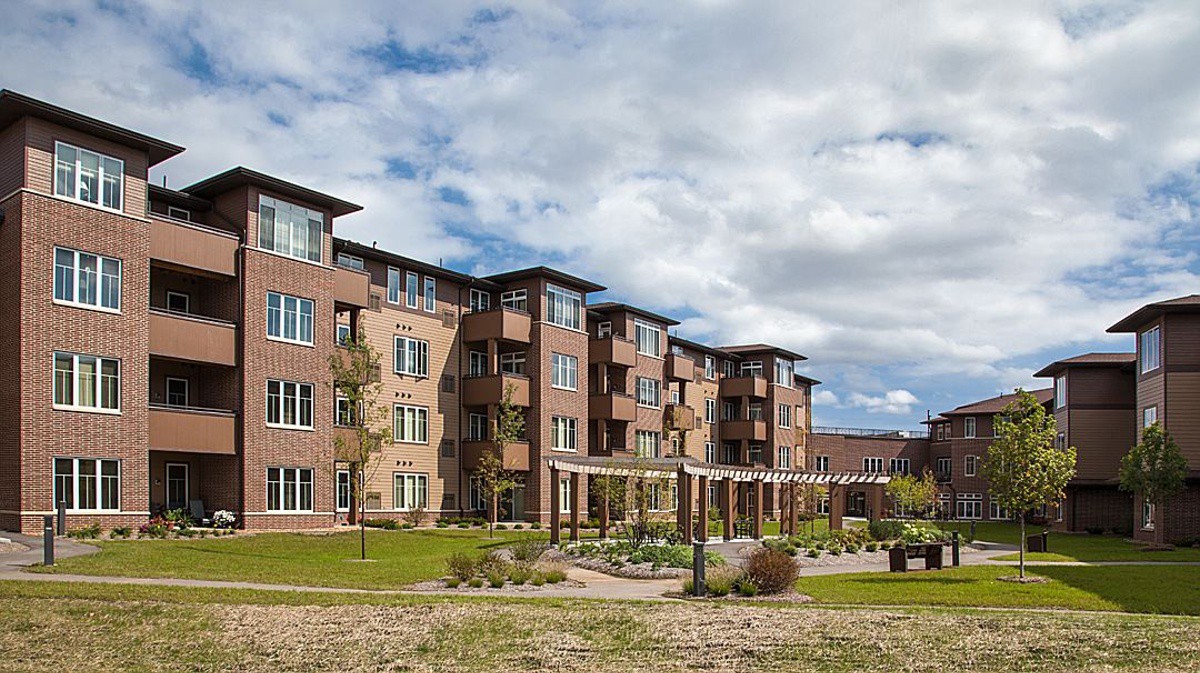 A view of a modern apartment building with landscaped gardens.