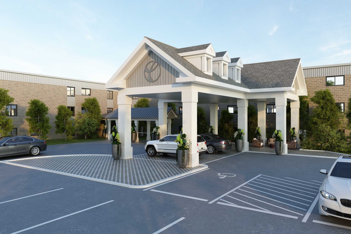 A hotel entrance with a covered driveway and parked cars.