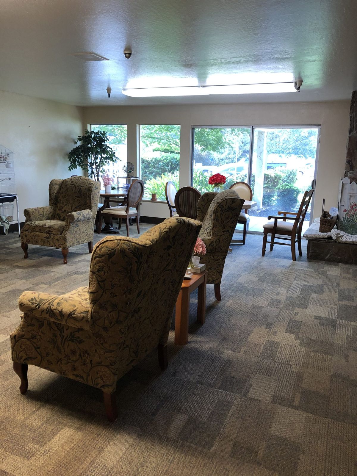A cozy living room with several chairs and a large window offering a view of the outdoors.