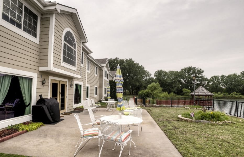 A spacious backyard featuring a patio with outdoor furniture and a well-maintained lawn.