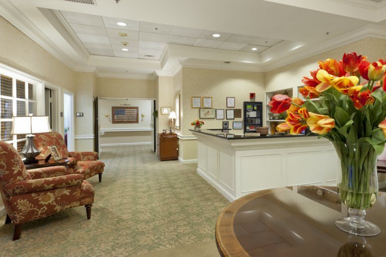 A well-lit reception area with comfortable seating and decorative flowers.