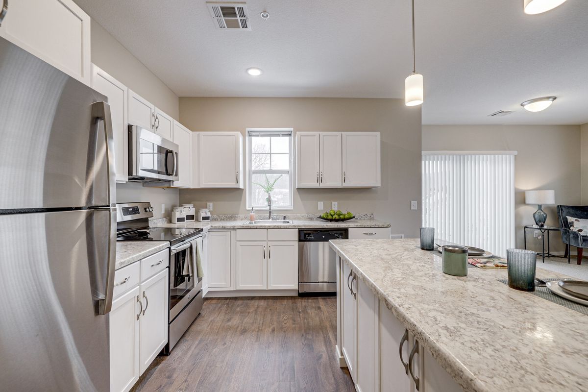 A modern kitchen with white cabinets, stainless steel appliances, and a spacious island.