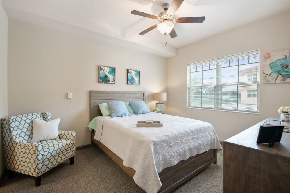 A cozy bedroom with a double bed, ceiling fan, and natural light coming through the window.