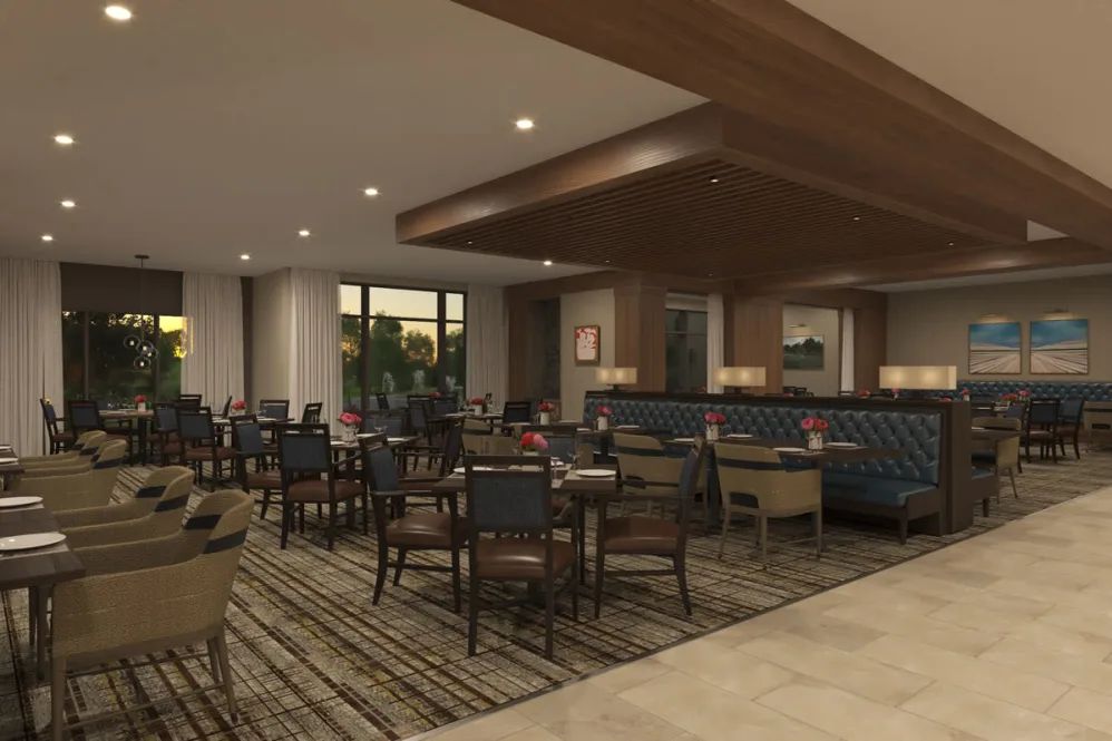 A modern restaurant dining area with neatly arranged tables and chairs, featuring warm lighting and elegant decor.