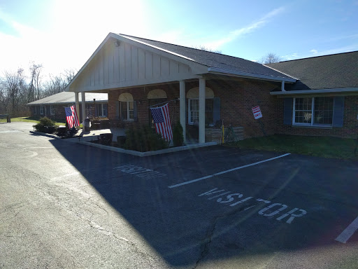 A sunny view of a residential building with flags displayed outside.