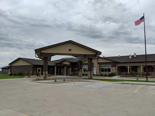 A welcoming entrance to a residential care facility under a cloudy sky.