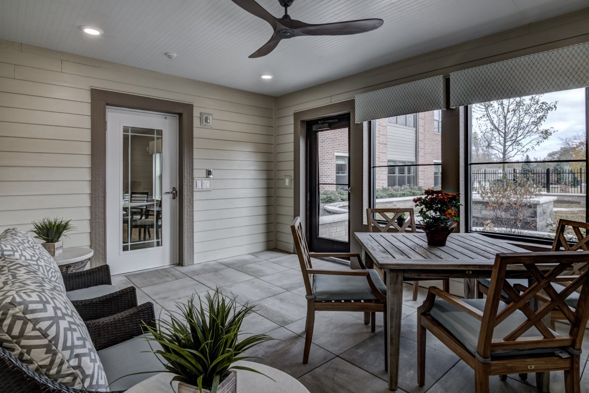 A cozy indoor patio featuring a dining set and decorative plants.