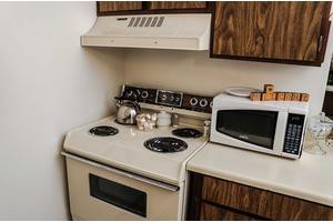 A retro-style kitchen with a stove, oven, and microwave.