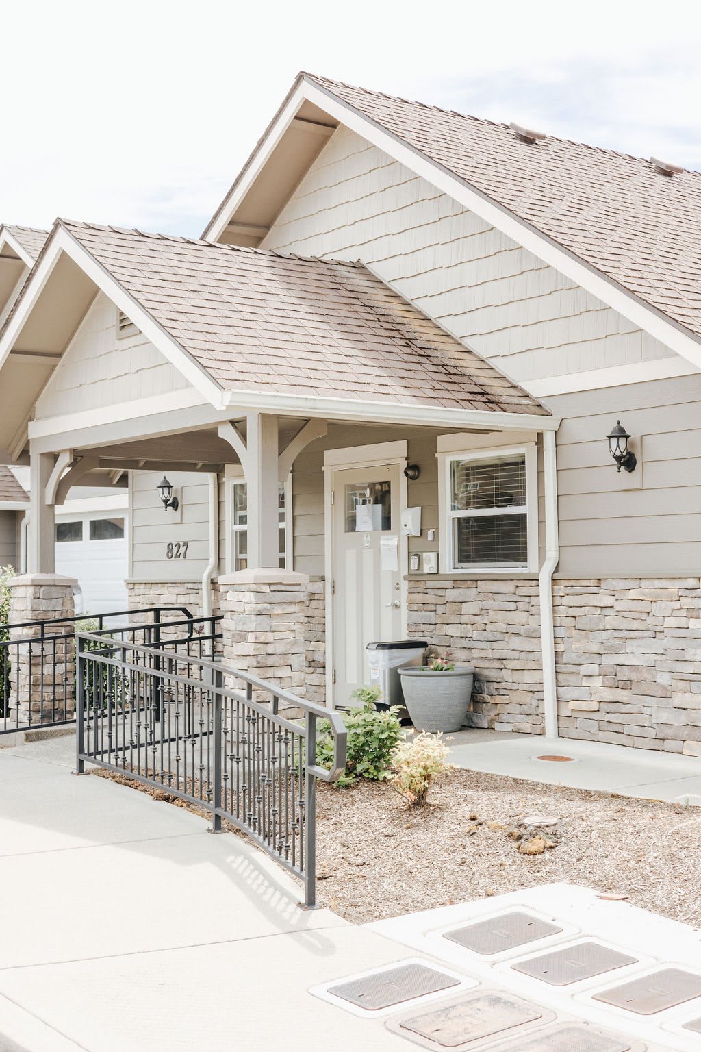 A modern house exterior with a front porch and accessibility ramp.