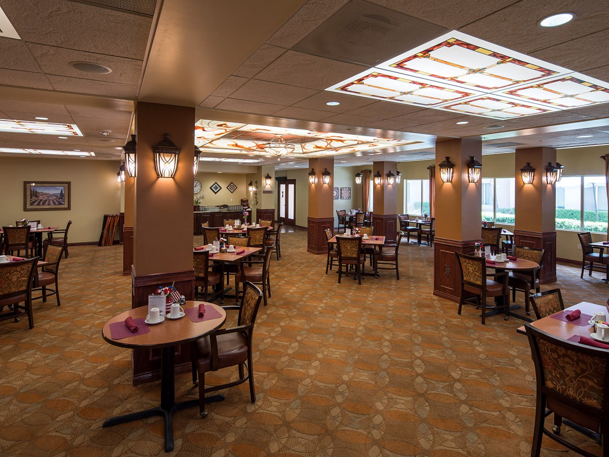 A spacious and elegantly decorated restaurant dining area with multiple tables and chairs.