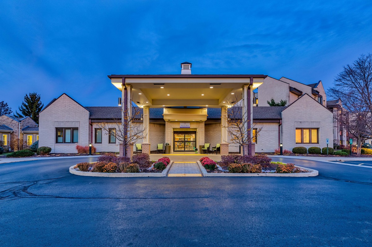 A well-lit hotel entrance with a modern architectural design at night.