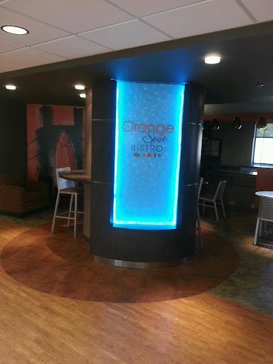 A modern interior view of a restaurant lobby featuring a glowing blue sign.