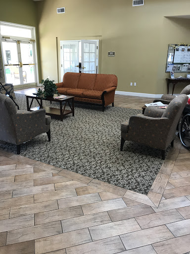 A cozy lobby area featuring a sofa, armchairs, and decorative carpet.