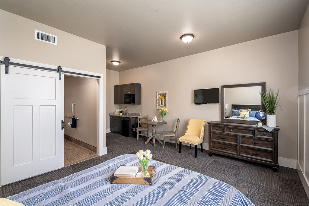 A modern and cozy bedroom with a kitchenette, featuring stylish furniture and decor.