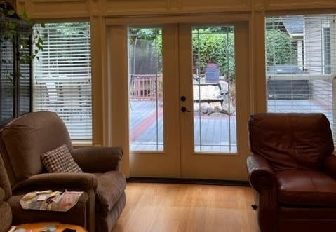 A cozy living room with French doors leading to a backyard patio.