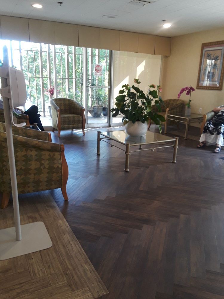 A comfortable waiting room with chairs, tables, and large windows.