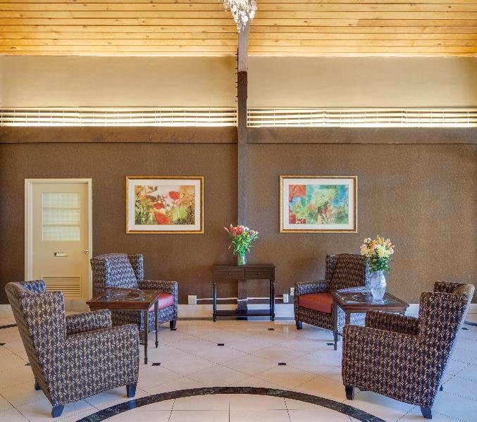 A well-designed lobby featuring comfortable chairs, vibrant artwork, and floral decorations.