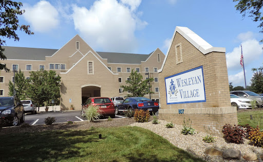 A view of a residential community building with parking and landscaping.