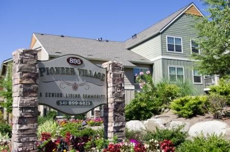 An apartment complex with a welcoming sign and well-maintained landscaping.