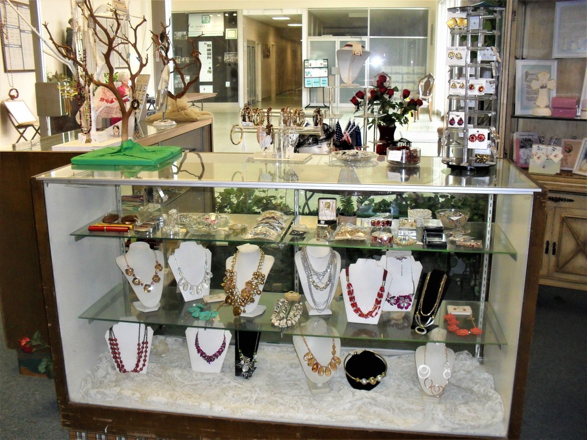 A glass display case showcasing various necklaces and jewelry in a store.