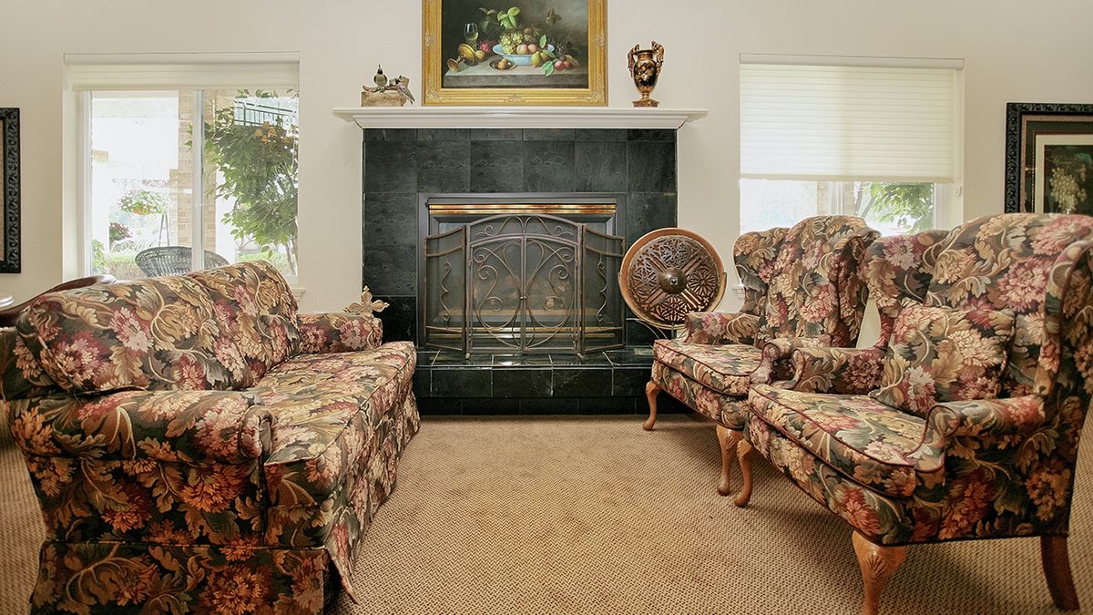 A traditional living room with floral furniture and a fireplace.