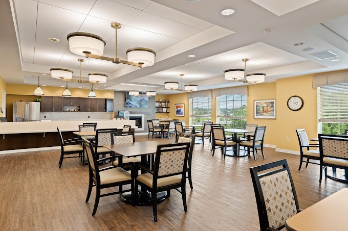 A modern dining area with neatly arranged tables and chairs, elegant lighting fixtures, and a welcoming atmosphere.