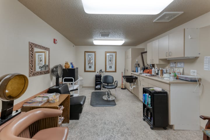 A view of a barbershop interior with chairs, mirrors, and hairdressing equipment.