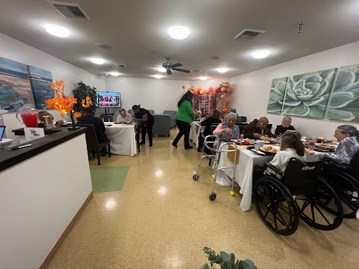 A lively gathering at a care facility, where residents enjoy a meal together.
