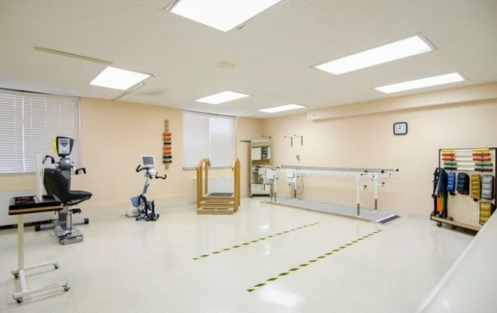 A clean and spacious physical therapy room equipped with exercise machines and rehabilitation tools.
