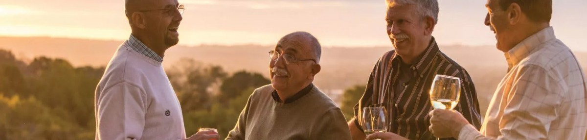 A man standing outdoors, smiling during sunset.