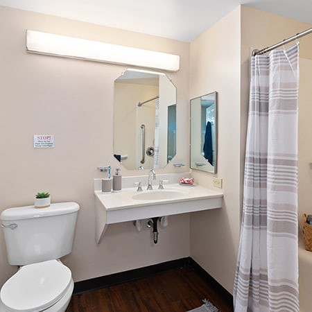 A clean and simple bathroom with a shower, sink, and toilet.