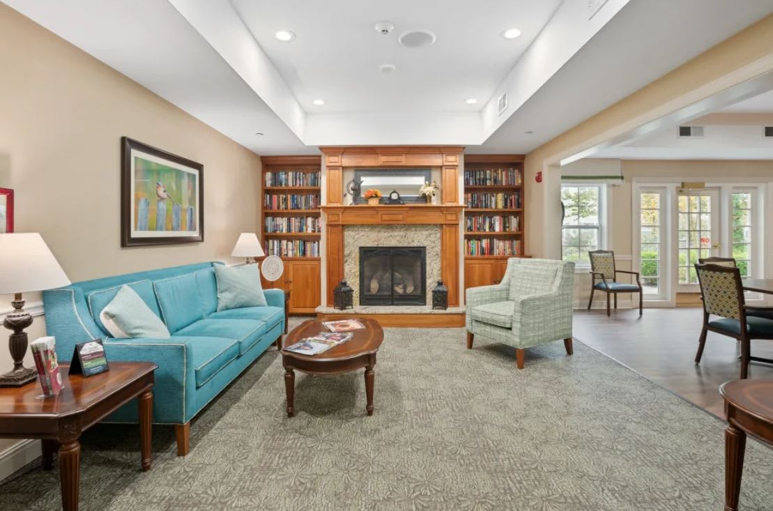 A cozy living room with a fireplace and bookshelves.