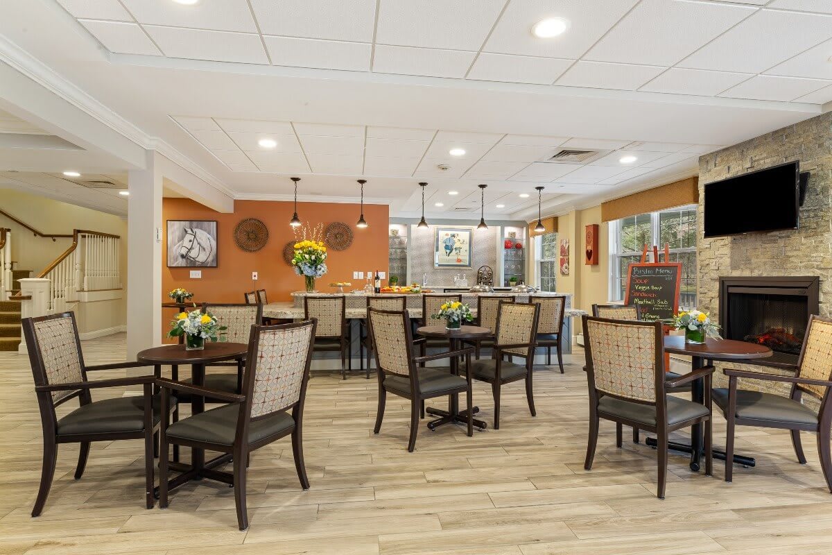 A well-lit dining area with neatly arranged tables and chairs, featuring tasteful decor and modern lighting.
