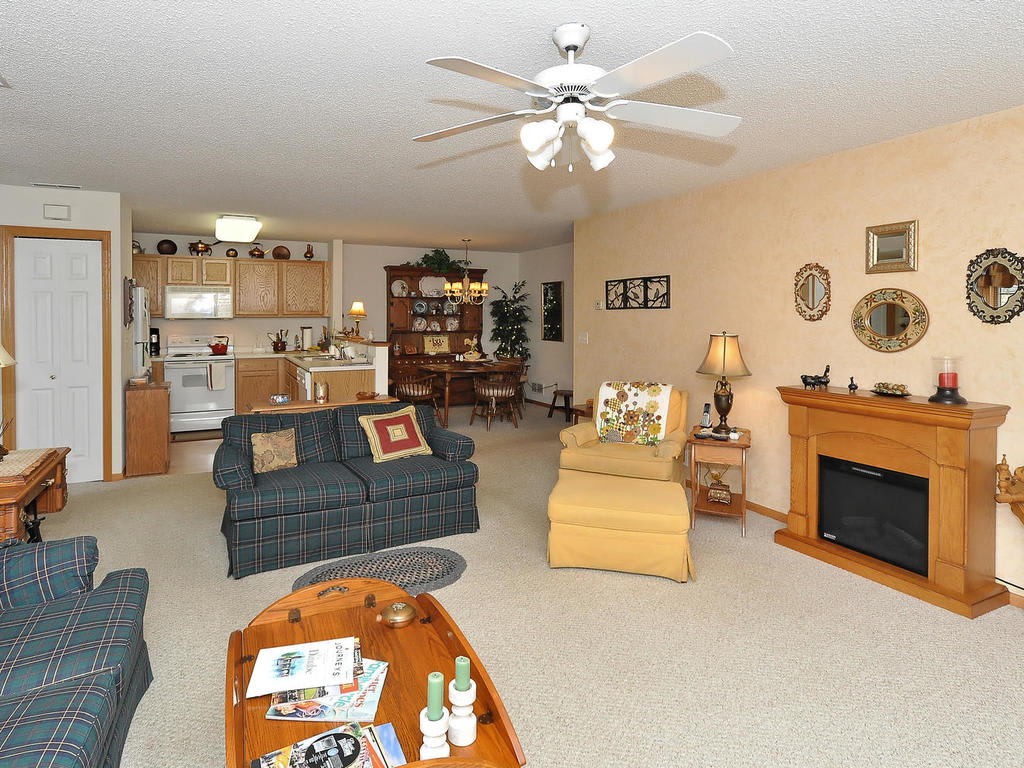 Spacious living room with an open layout, featuring cozy furniture and a fireplace.