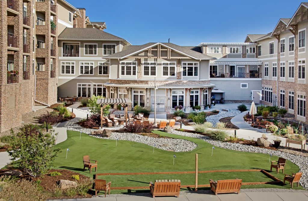 A spacious and elegant residential building with landscaped gardens and outdoor seating areas.