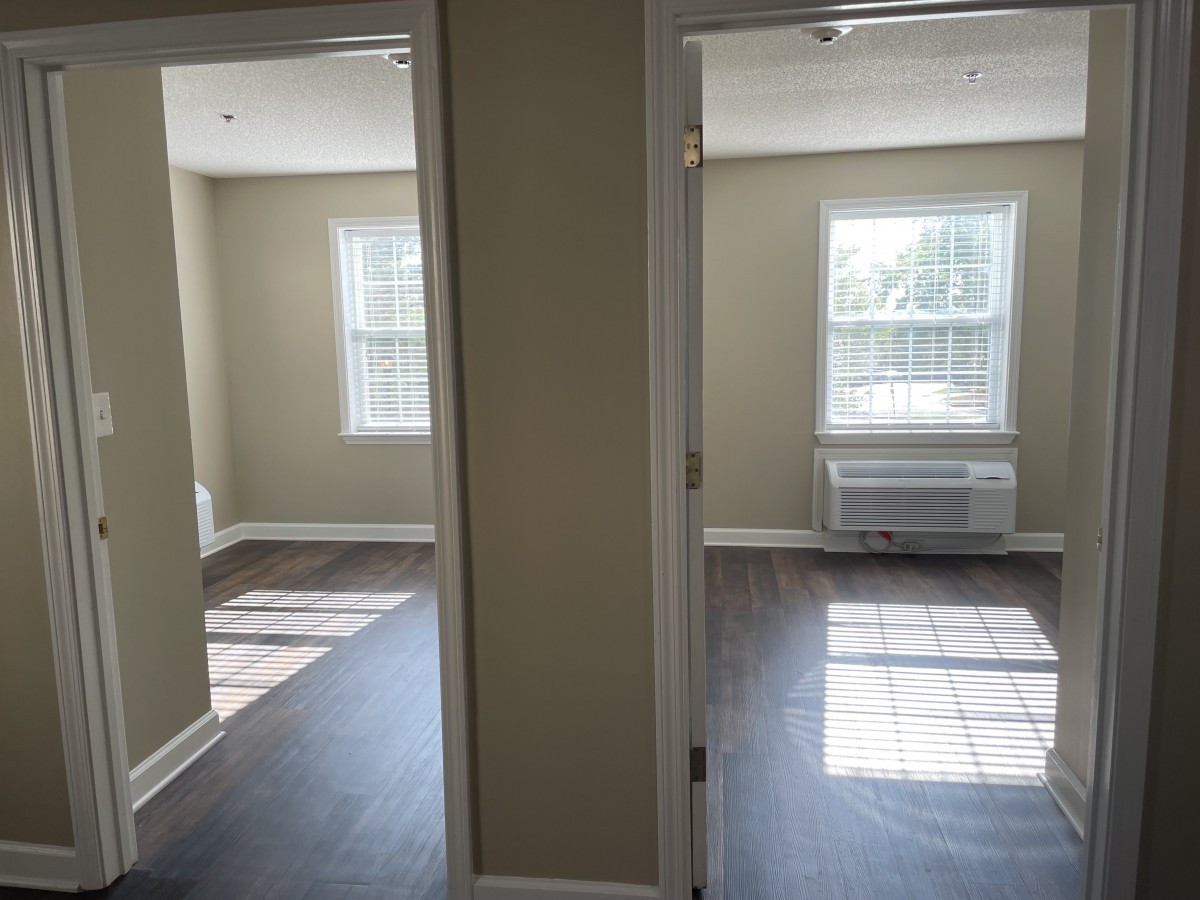 Two empty rooms with large windows and sunlight streaming in.