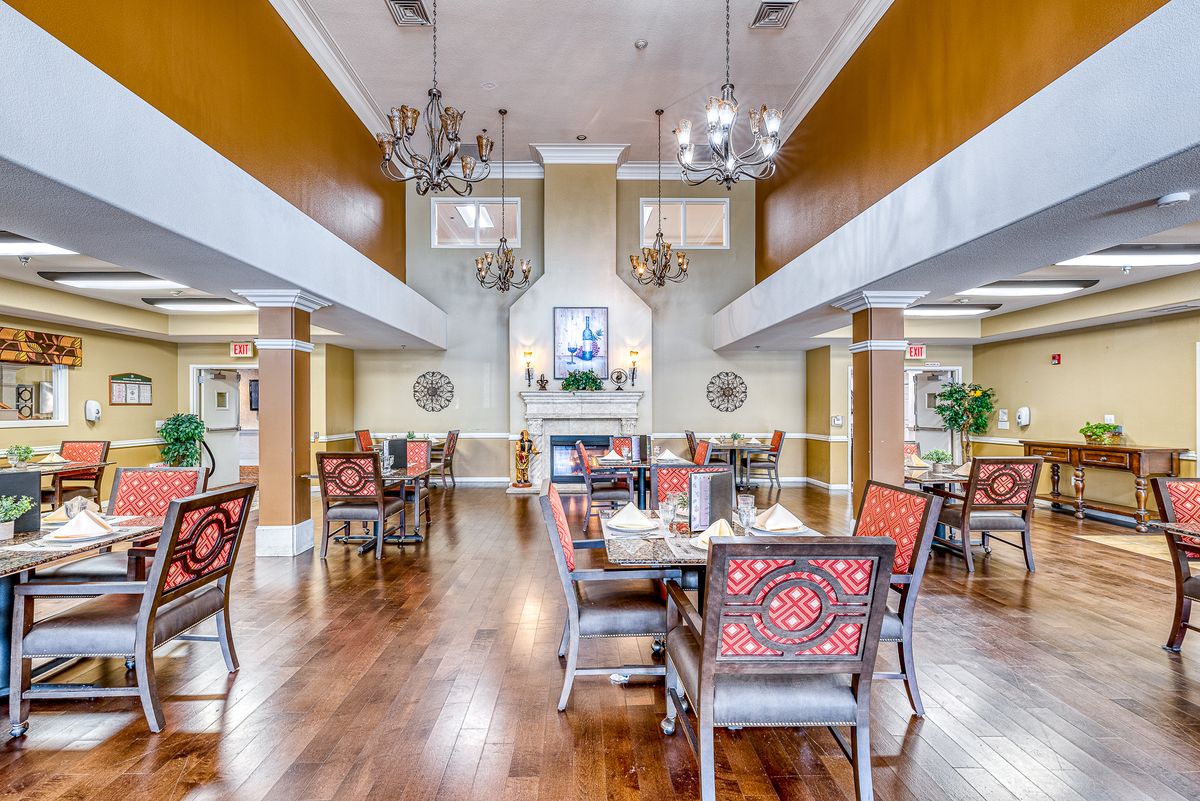 Elegant dining area with chandeliers and wooden flooring.